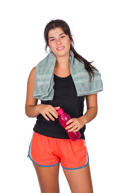 Mujer atlética con una toalla y sosteniendo una botella de agua.