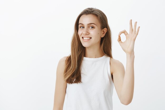 Mujer atractiva de apoyo que muestra un gesto bien, elogia la elección perfecta, hace un cumplido, dice que sí, aprueba