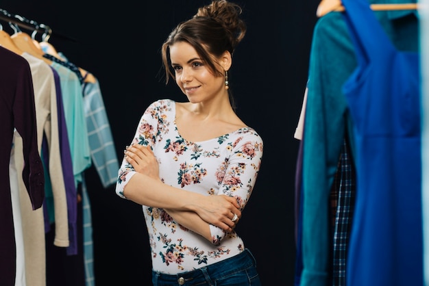 Mujer atractiva entre bastidores de ropa