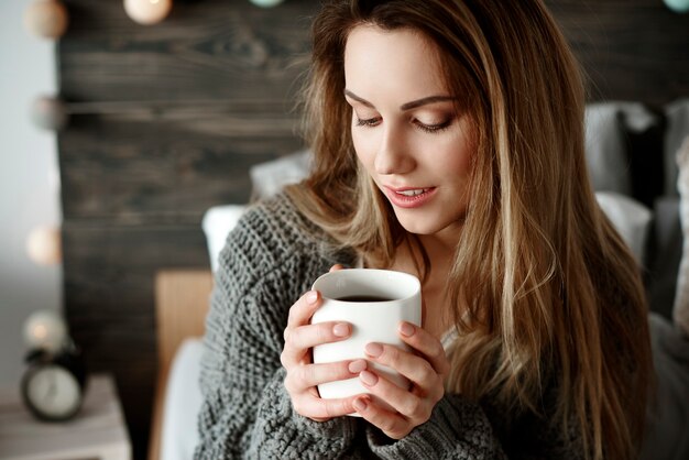 Mujer atractiva bebiendo café por la mañana