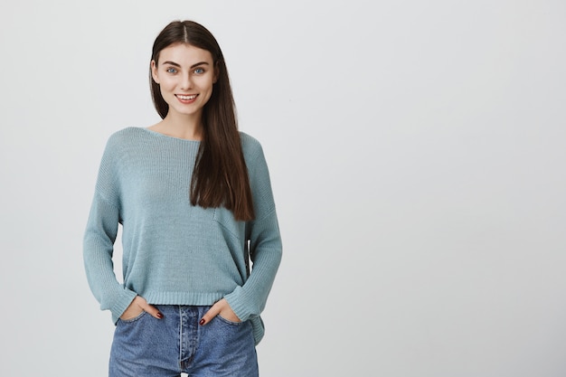 Mujer atractiva con cabello oscuro, sonriendo satisfecha