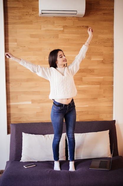 Foto gratuita mujer atractiva cansada trabajar en casa estirando los brazos para relajarse después de un día duro