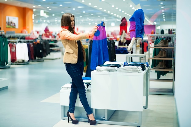 Mujer atractiva eligiendo paños en la tienda