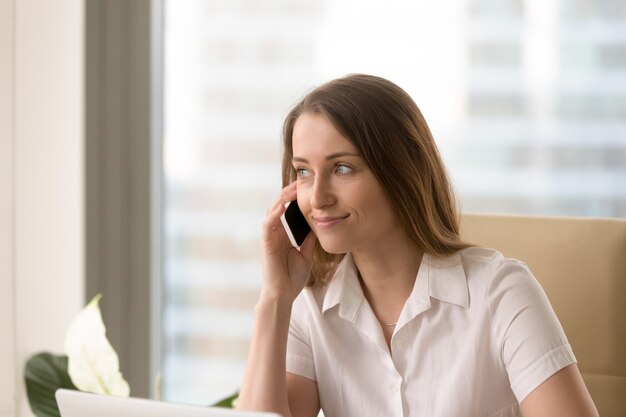 Mujer atractiva escuchando mensajes de correo de voz