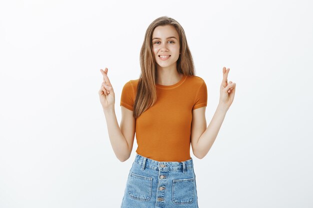 Mujer atractiva esperanzada que desea. Chica esperando que el sueño se haga realidad. Estudiante deseando, esperando buena fortuna