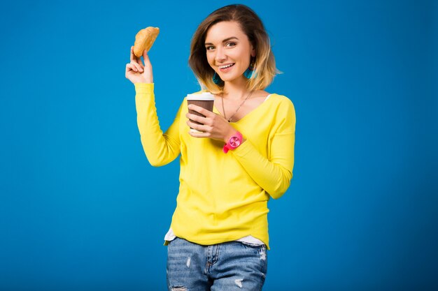 Mujer atractiva con estilo joven en blusa amarilla sobre azul