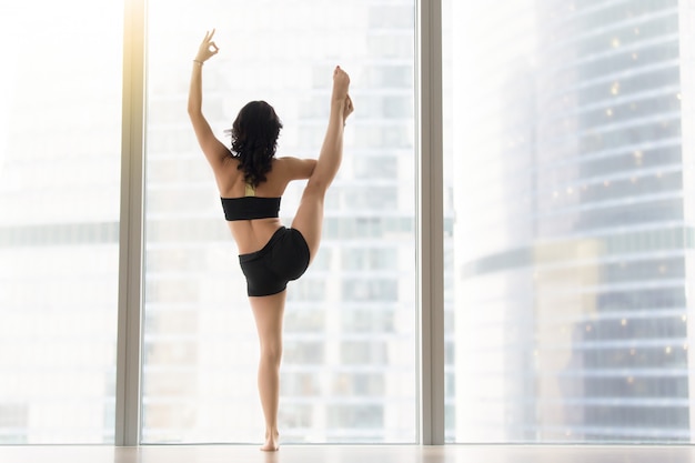 Mujer atractiva joven en la actitud de Utthita Hasta Padangusthasana