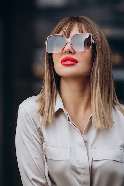 Mujer atractiva joven con labios rojos posando en la calle
