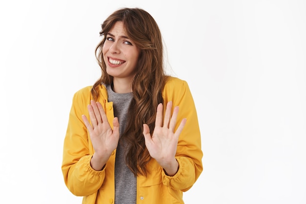 Foto gratuita mujer atractiva joven nerviosa incómoda disculpándose por la negativa tratando de escapar de la situación incómoda retroceder agacharse sonriendo tomarse de las manos gesto de parada de rechazo