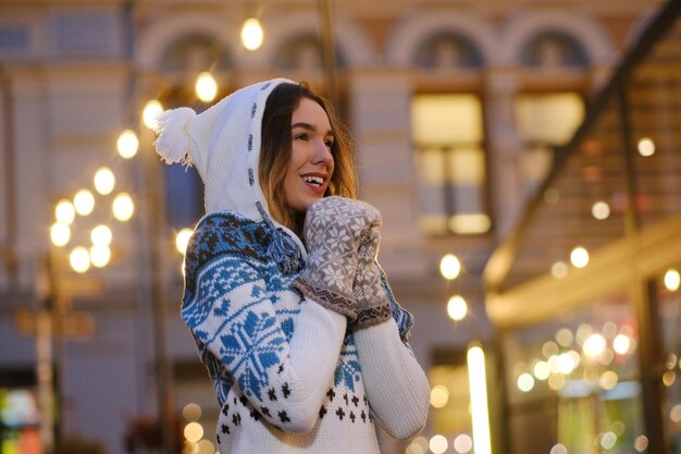 Mujer atractiva joven en puente de invierno se siente feliz en Nochebuena.