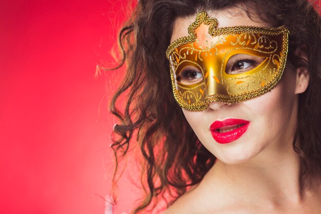 Mujer atractiva en máscara de oro