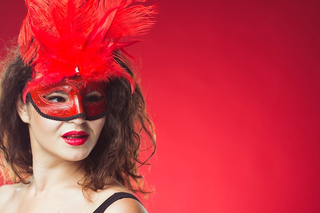 Foto gratuita mujer atractiva posando en máscara roja