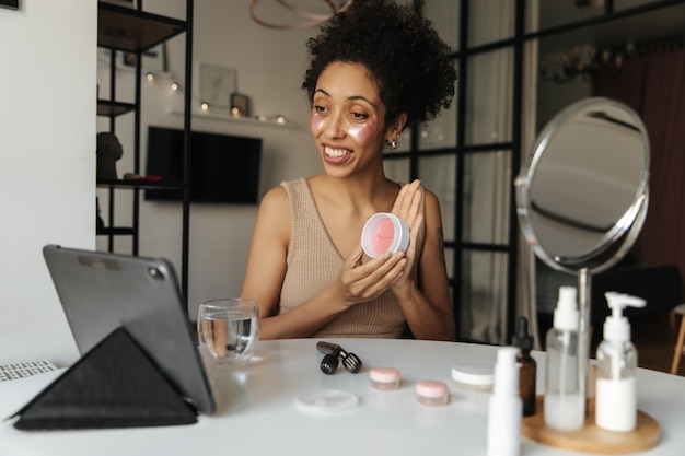 Mujer atractiva que muestra productos para la cara