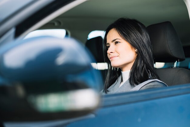 Mujer atractiva sentada en coche