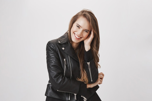 Mujer atractiva sonriente que toca el pelo