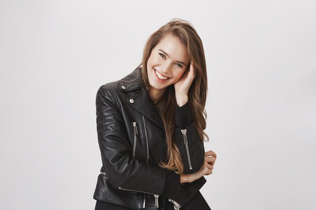 Mujer atractiva sonriente que toca el pelo