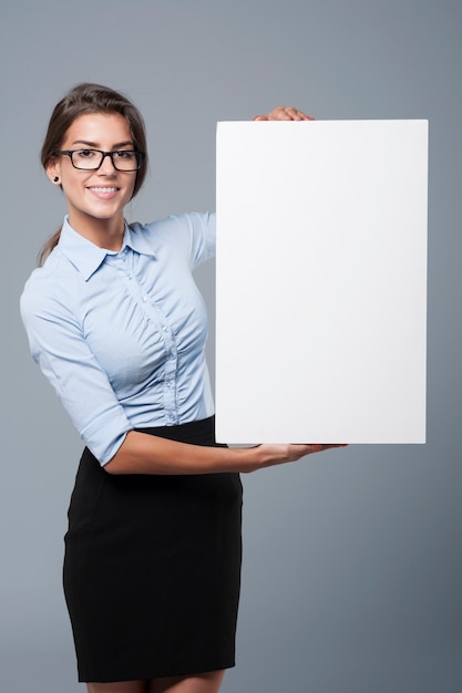 Foto gratuita mujer atractiva sosteniendo un cartel blanco