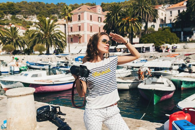 Mujer atractiva de vacaciones en Europa junto al mar en un crucero tomando fotografías con la cámara