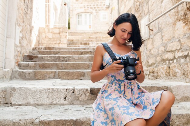 Mujer atractiva en vestido treveling de vacaciones en el centro de la ciudad vieja de Italia tomando fotografías en la cámara