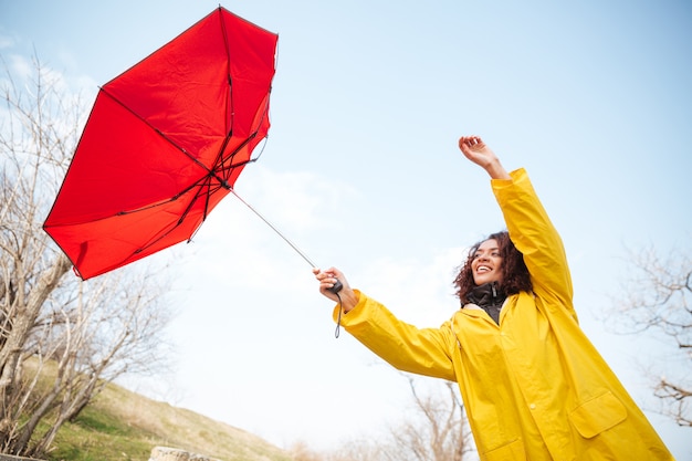 Mujer atrapando paraguas volador