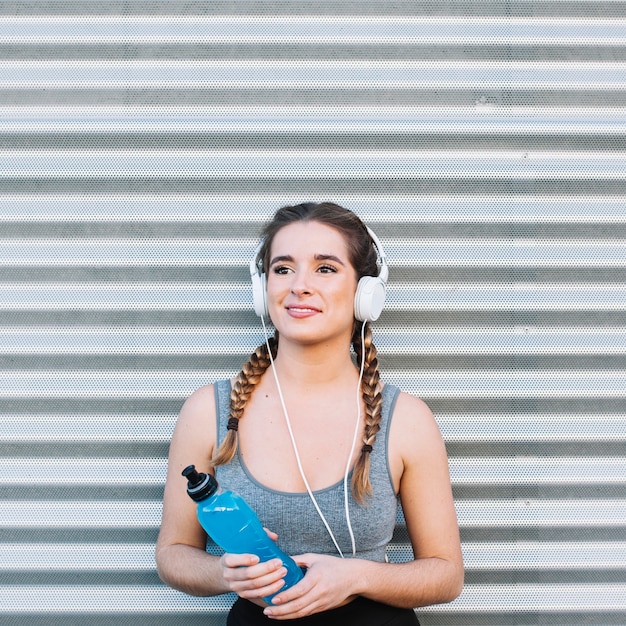 Foto gratuita mujer con auriculares y bebida