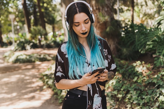 Mujer con auriculares en la cabeza con teléfono móvil