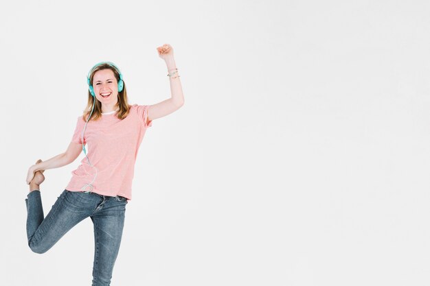 Mujer en auriculares enérgicamente bailando