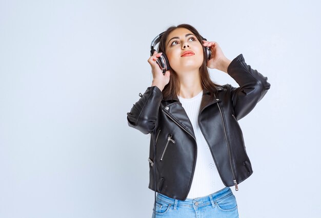 mujer con auriculares escuchando música y bailando.