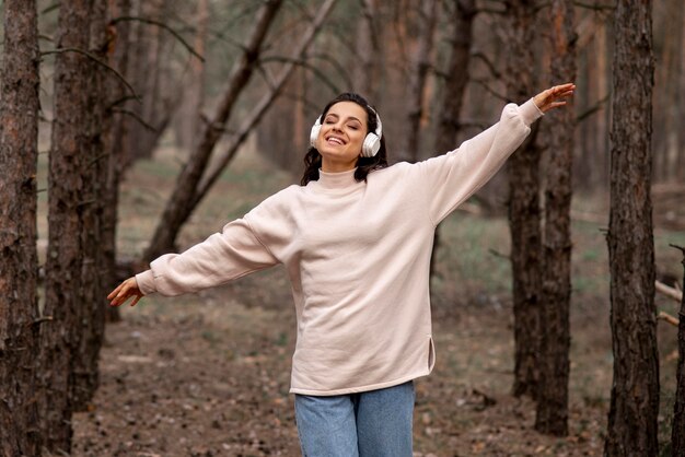 Mujer con auriculares explorando la naturaleza