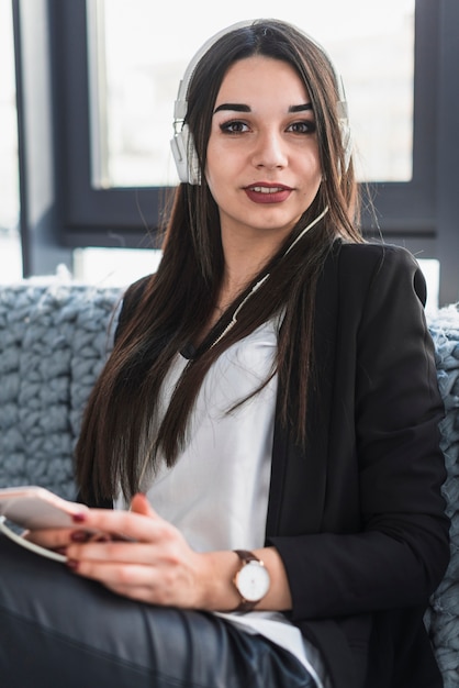 Mujer en auriculares mirando a la cámara