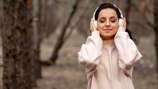 Mujer con auriculares en la naturaleza