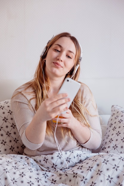 Mujer en auriculares posando para selfie