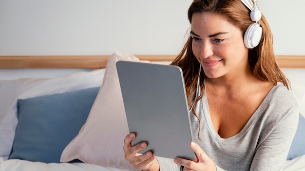 Mujer con auriculares con tableta