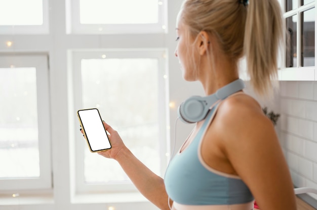 Foto gratuita mujer con auriculares mediante teléfono