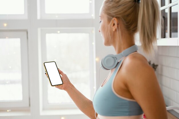 Mujer con auriculares mediante teléfono