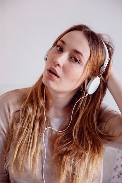 Foto gratuita mujer en auriculares tocando el cabello