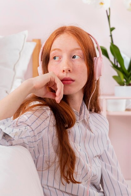 Mujer con auriculares trabajando desde casa