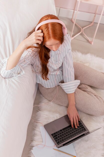 Mujer con auriculares trabajando desde casa