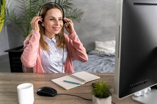 Foto gratuita mujer con auriculares trabajando en equipo