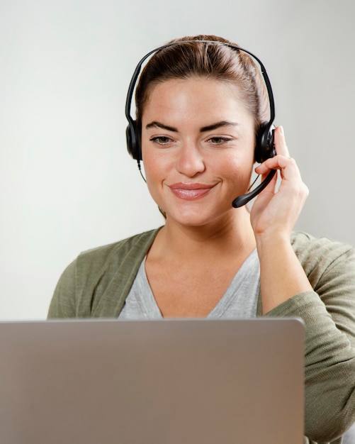 Mujer con auriculares usando laptop