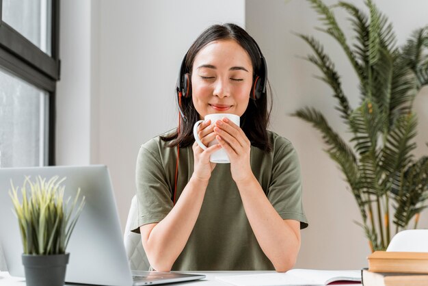 Mujer con auriculares con videollamada en portátil