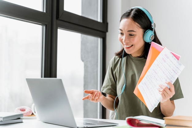 Foto gratuita mujer con auriculares con videollamada en portátil