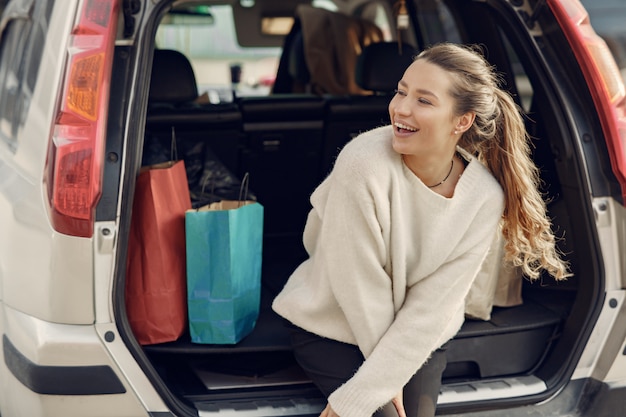 Mujer en el auto con bolsas de compras