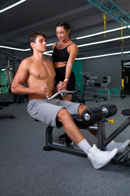 Mujer ayudando al hombre a entrenar vista lateral