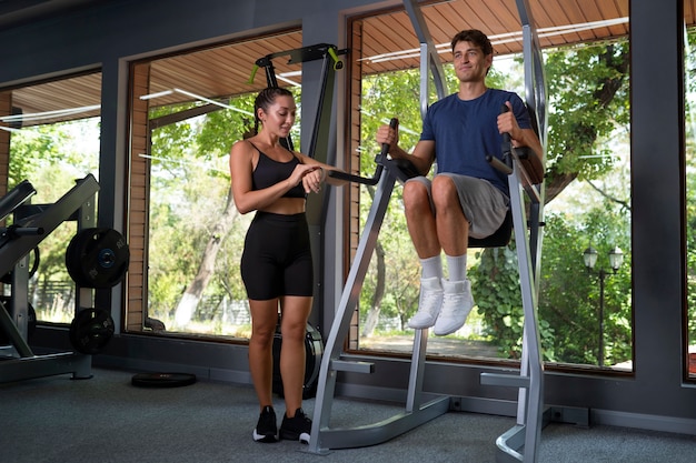 Mujer ayudando a hombre a entrenar tiro completo