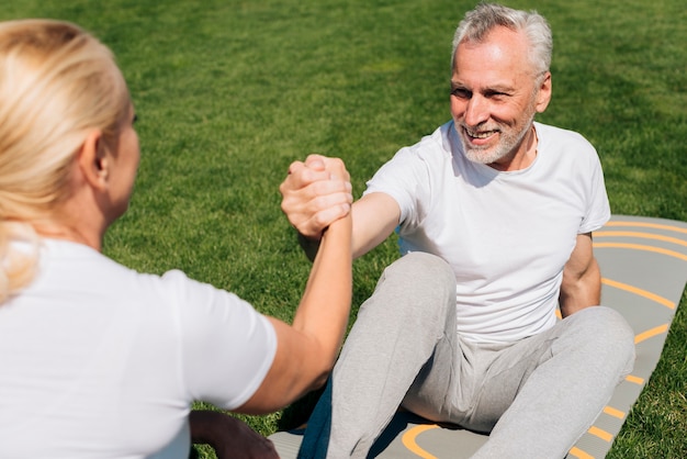 Foto gratuita mujer ayudando a hombre a levantarse