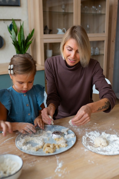 Mujer ayudando a los niños a cocinar vista frontal