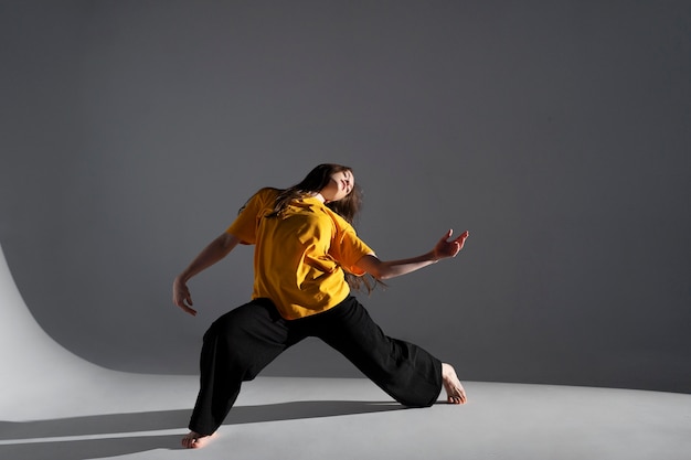 Mujer bailando en tiro completo de estudio