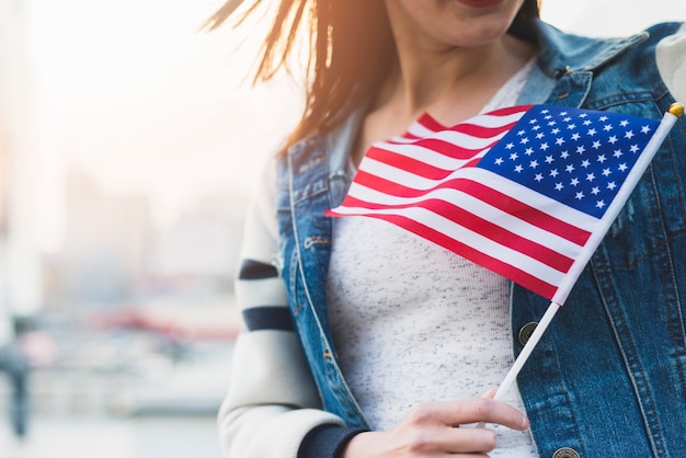 Mujer con bandera americana en palo en mano