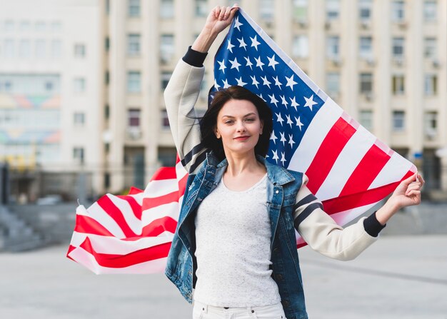 Mujer con bandera de Estados Unidos en la calle